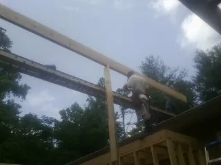 Carpenter setting a ridge beam over a new addition frame — Ice Dam Removal by Roofing Brothers in Saline