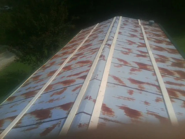 Rusted metal roof panels with new wood purlins before replacement — Storm Damage Roof Repair in Saline by Roofing Brothers