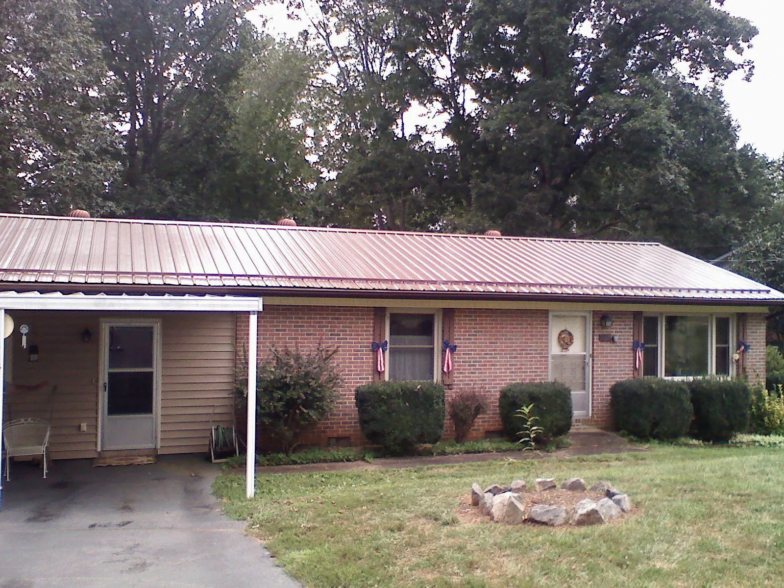 Bronze metal roof and carport on a brick ranch home — Roof Repair work by our crew in Saline
